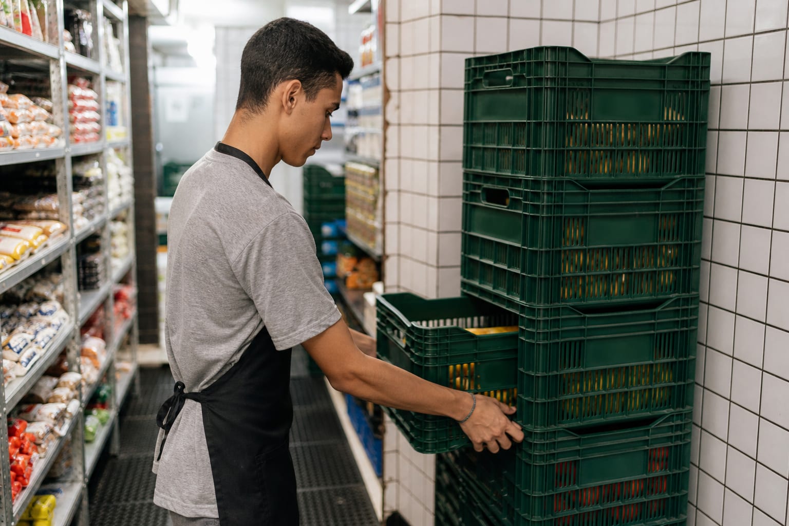 Repositor abastece prateleira puxando os produtos antigos para a frente da gôndola